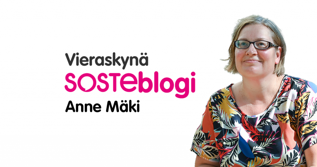 Anne Mäki hymyilee lyhythihaisessa puserossa.