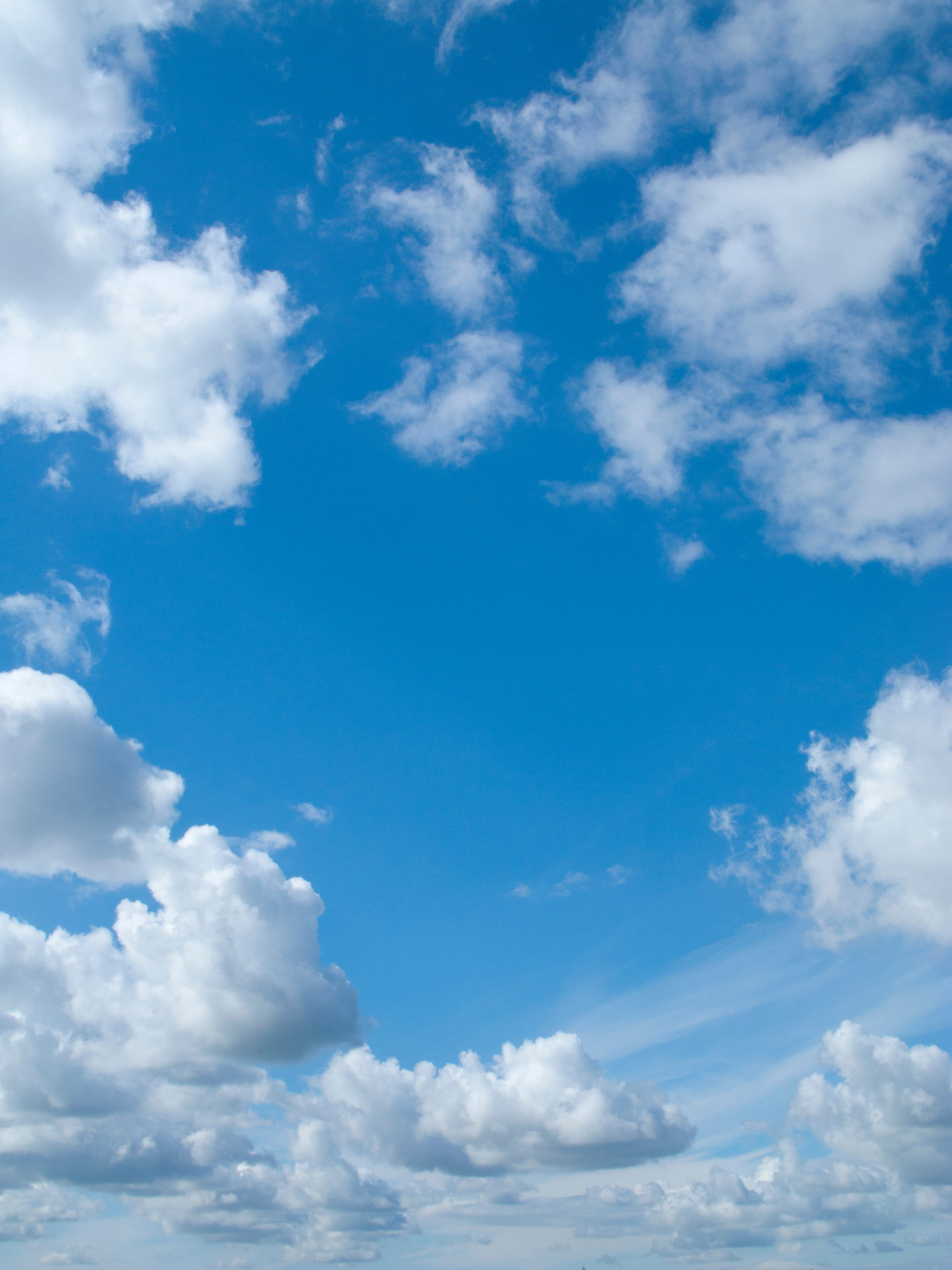 Valokuva sinisestä taivaasta valkoisine kumpupilvineen